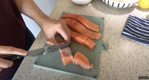 Salmon fillets being cut into fifths