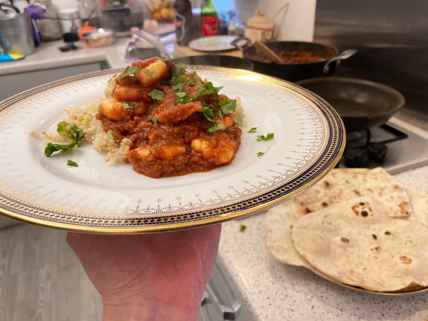 King Prawn Madras served on a fancy plate with homemade flatbreads in the background