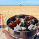 eating kale, black bean, chilli and feta salad at the beach