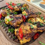 Barbecued turmeric chicken thighs with chilli and coriander garnish